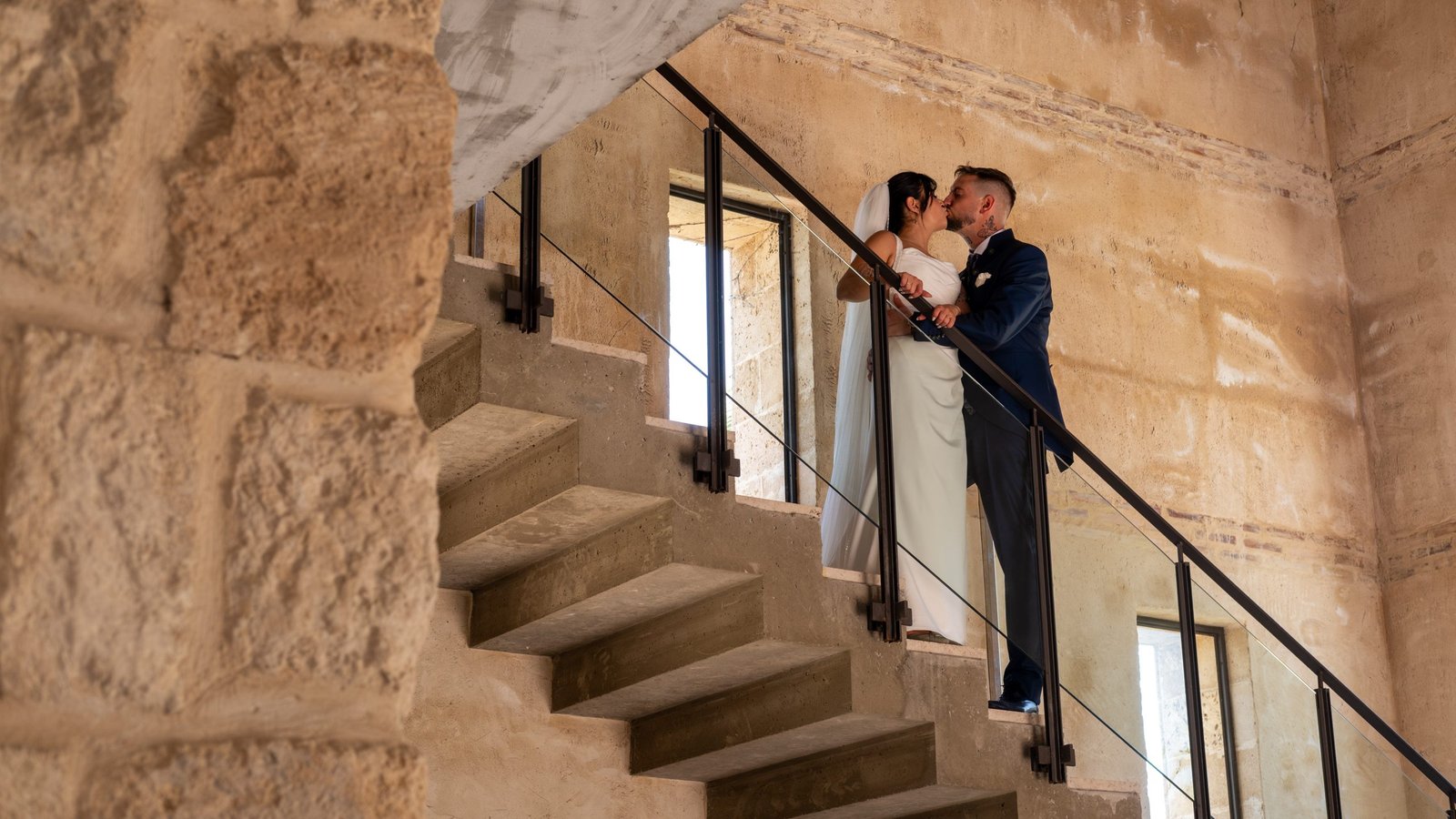 Beso de los novios en una escalera de piedra