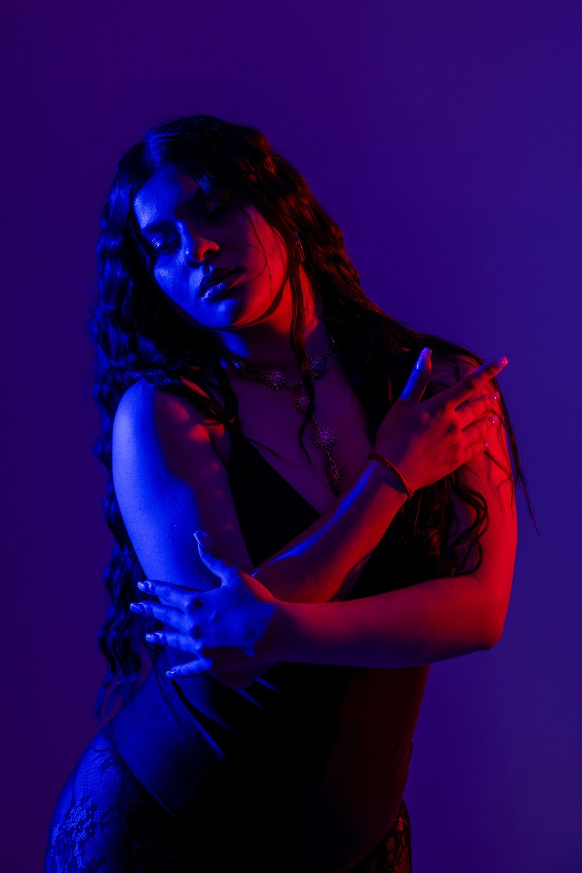 Retrato con luz azul y roja, brazos cruzados