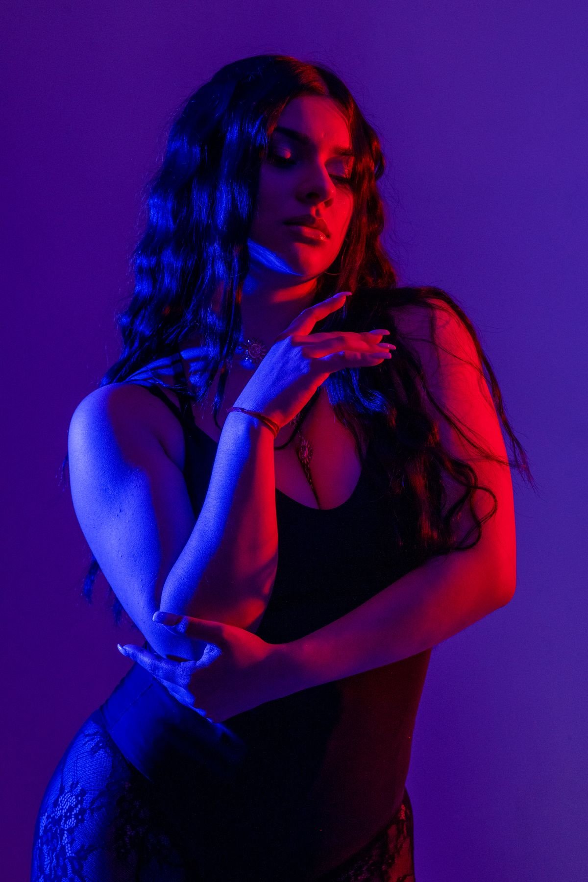 Retrato con luz azul y roja, mano en el cuello
