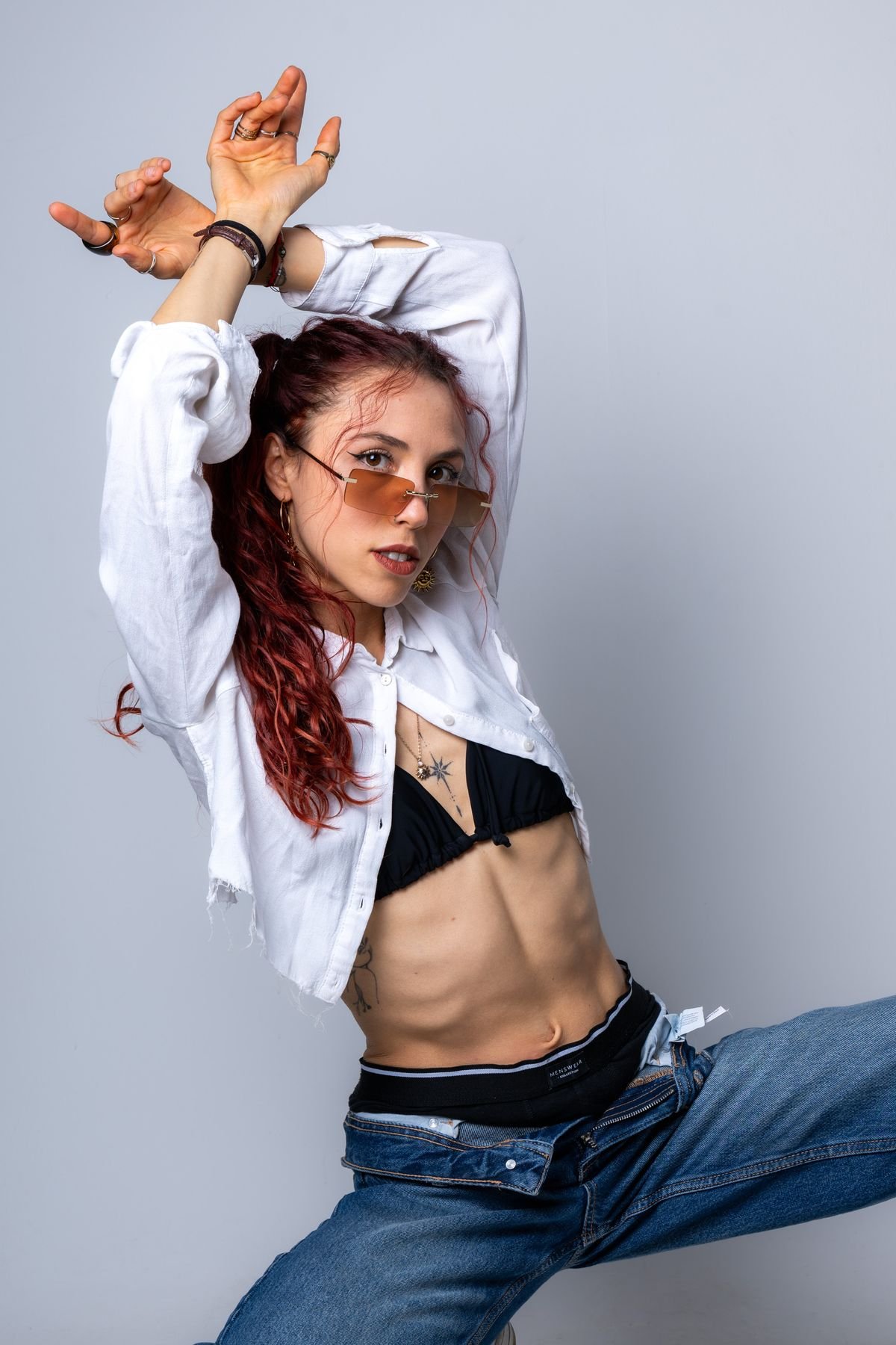 Retrato con camisa blanca y brazos en alto