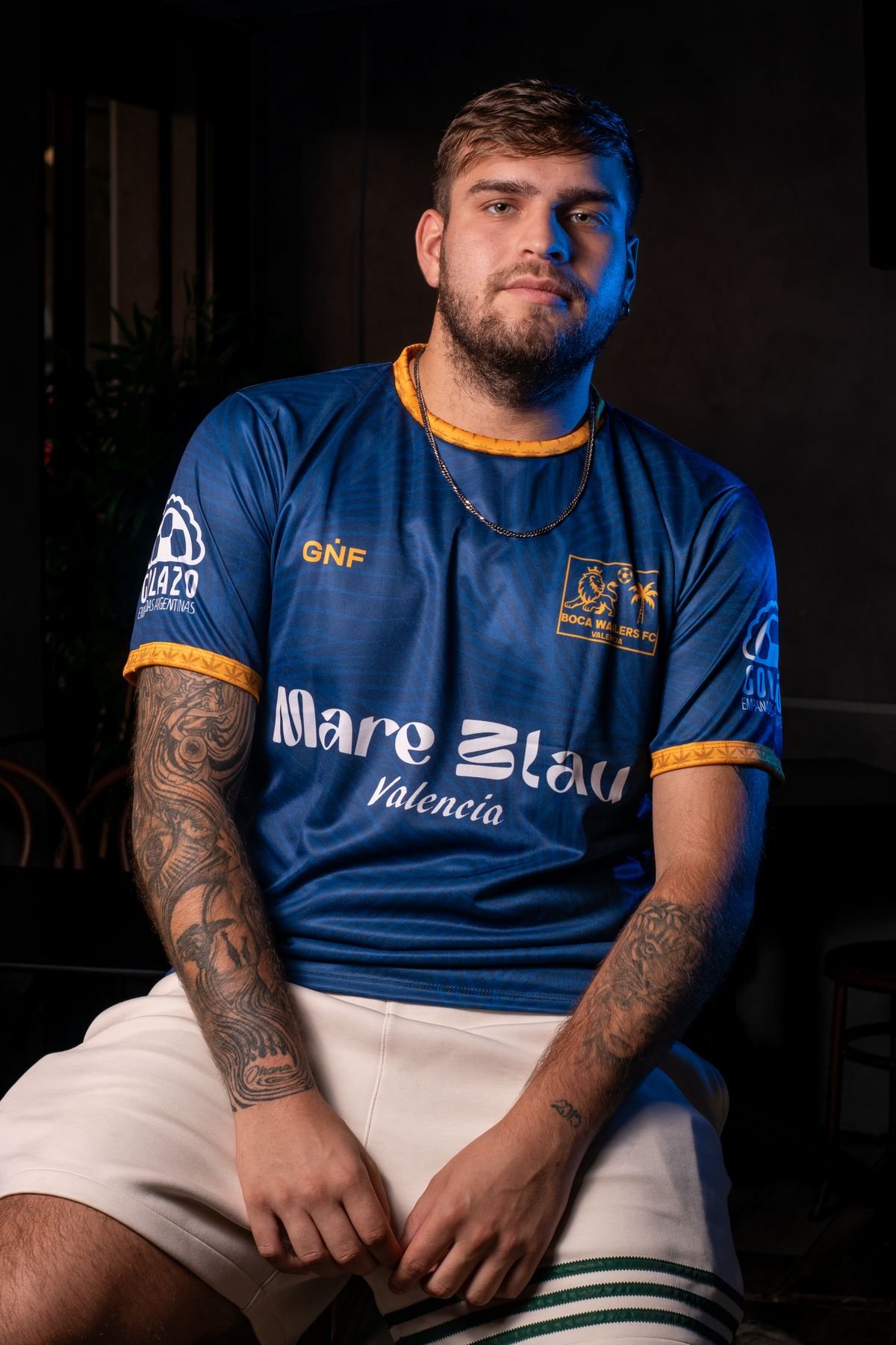 Jugador sentado con camiseta azul y shorts blancos