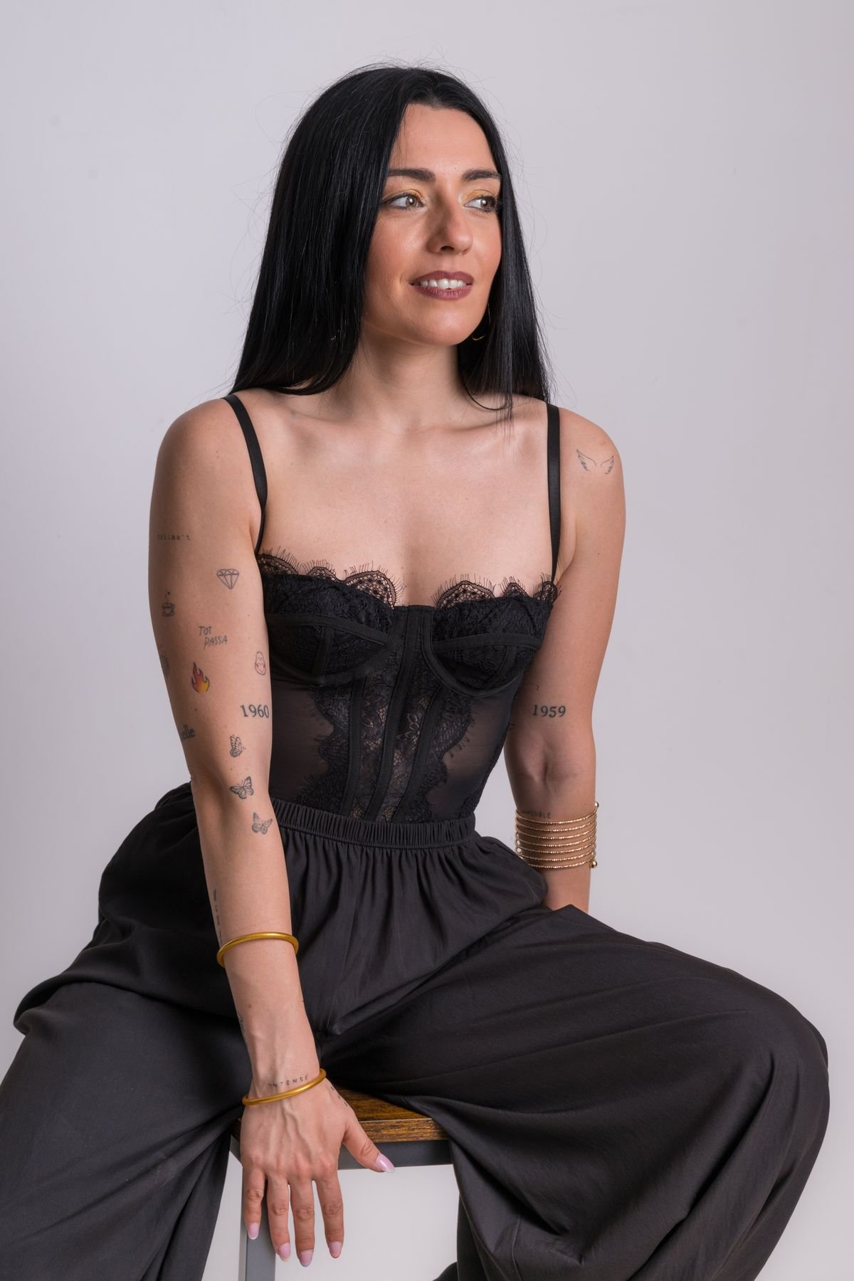 Mujer con corsé negro sentada sonriendo