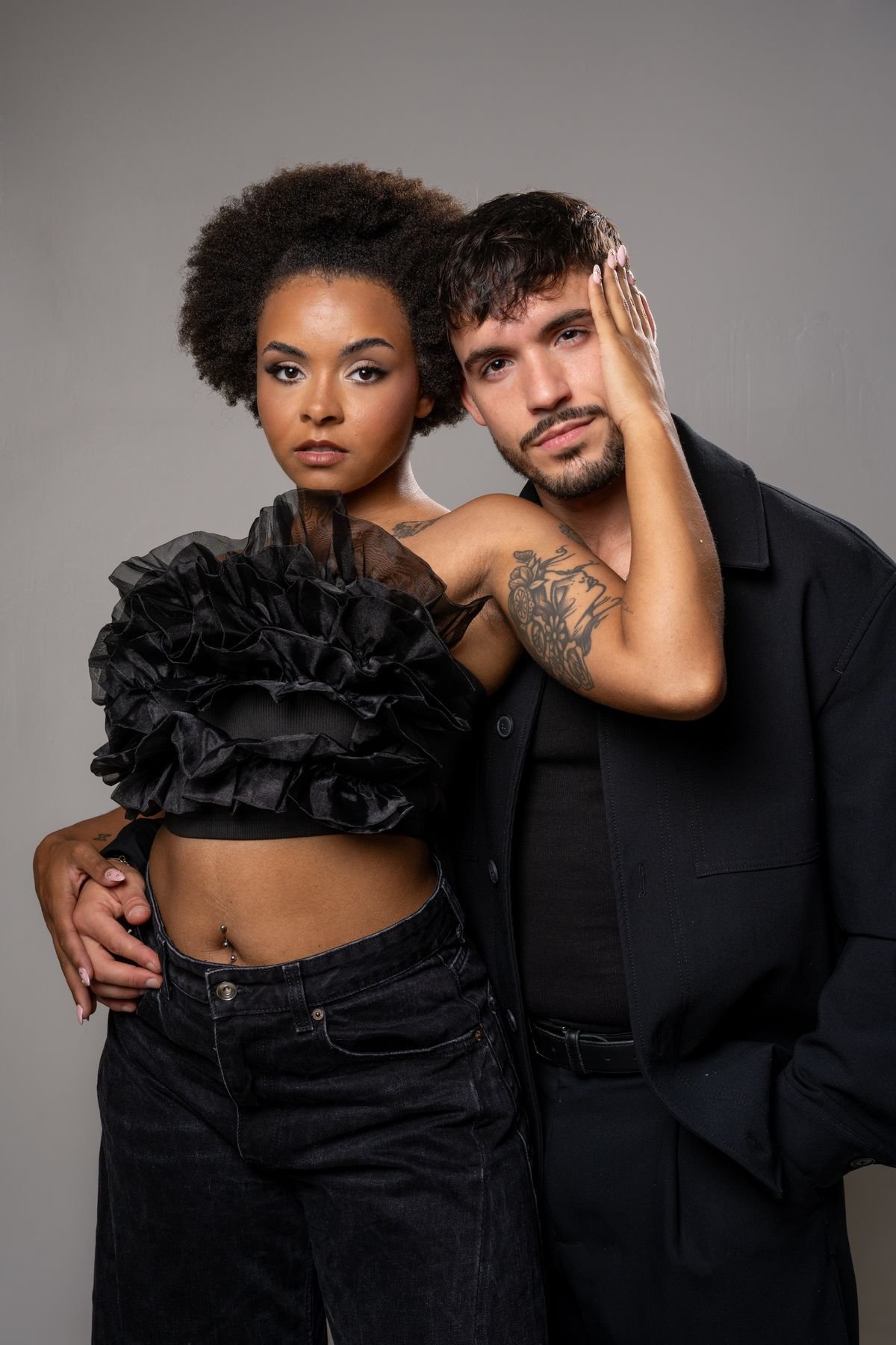 Pareja vestida de negro, ella le toca la cara